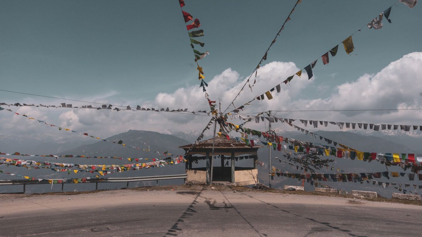 Inner line permit route to Tawang with prayer flags on a mountain road in Arunachal Pradesh