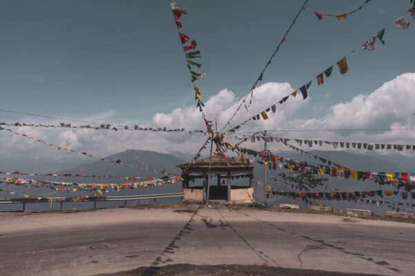 Inner line permit route to Tawang with prayer flags on a mountain road in Arunachal Pradesh