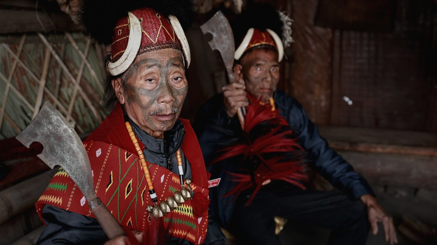 Kisama Heritage Village visitors meet Naga warriors in traditional attire inside a morung