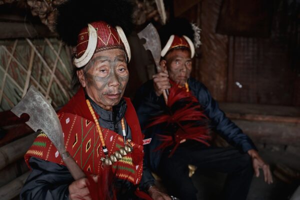 Kisama Heritage Village visitors meet Naga warriors in traditional attire inside a morung