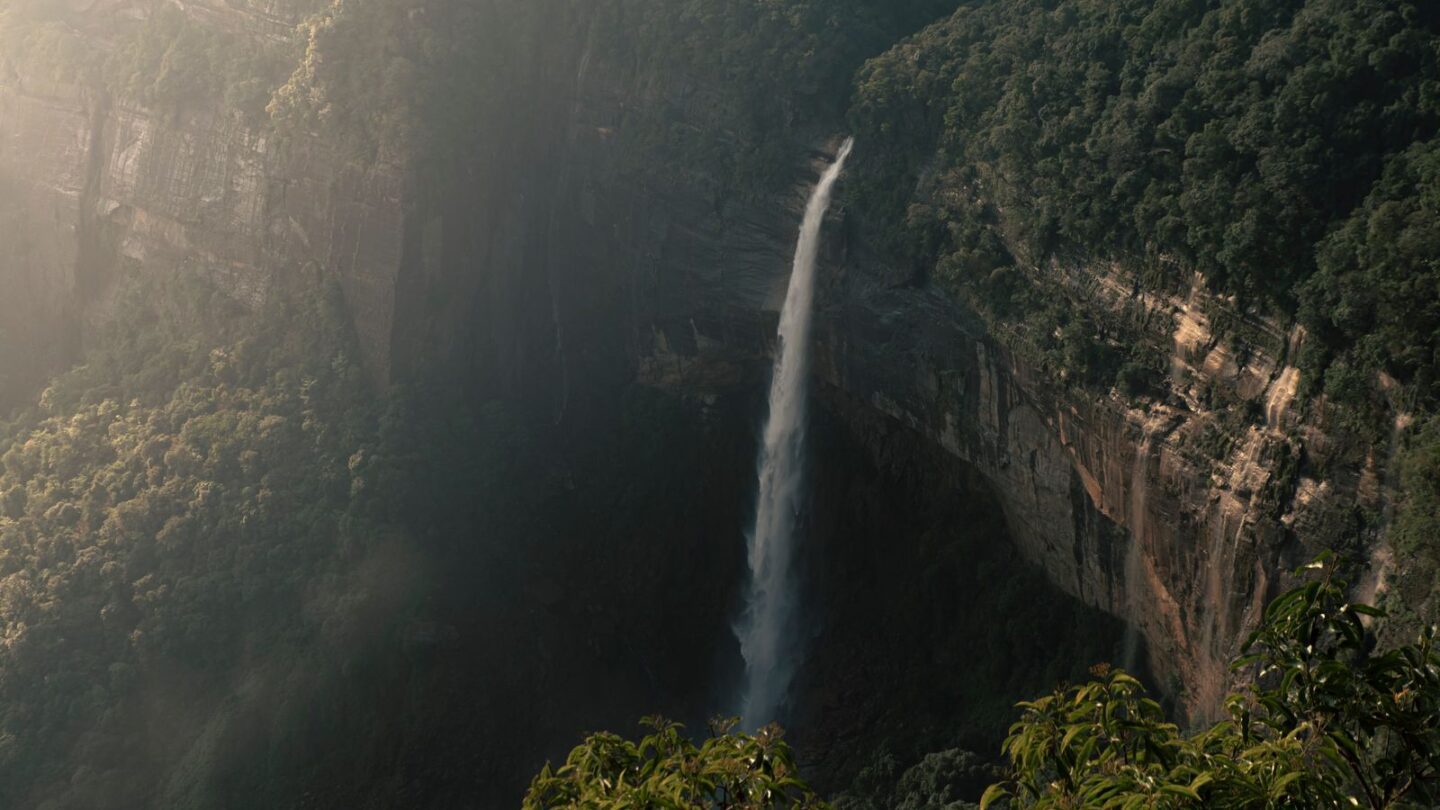 Cherrapunji's Nohkalikai Falls plunging from a green cliff into a pool in Meghalaya