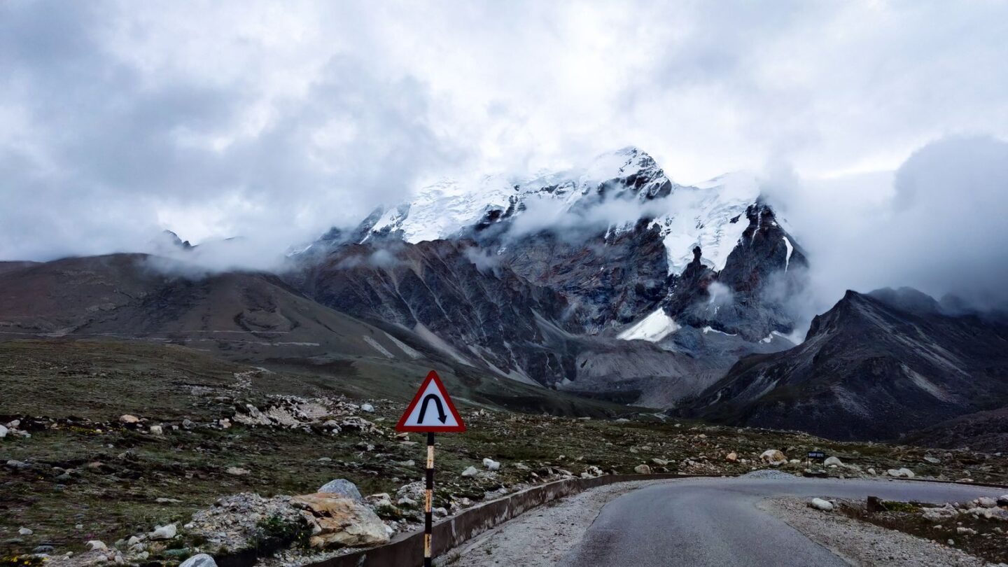 Sikkim permit zone road curving towards snow mountains in North Sikkim